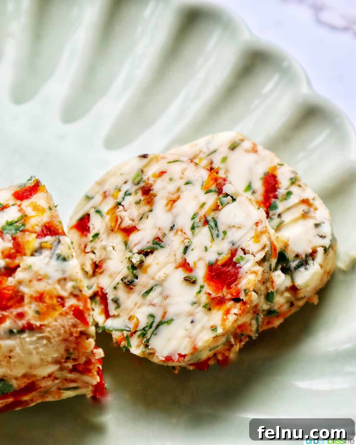 Slices of sun-dried tomato butter on a green plate.