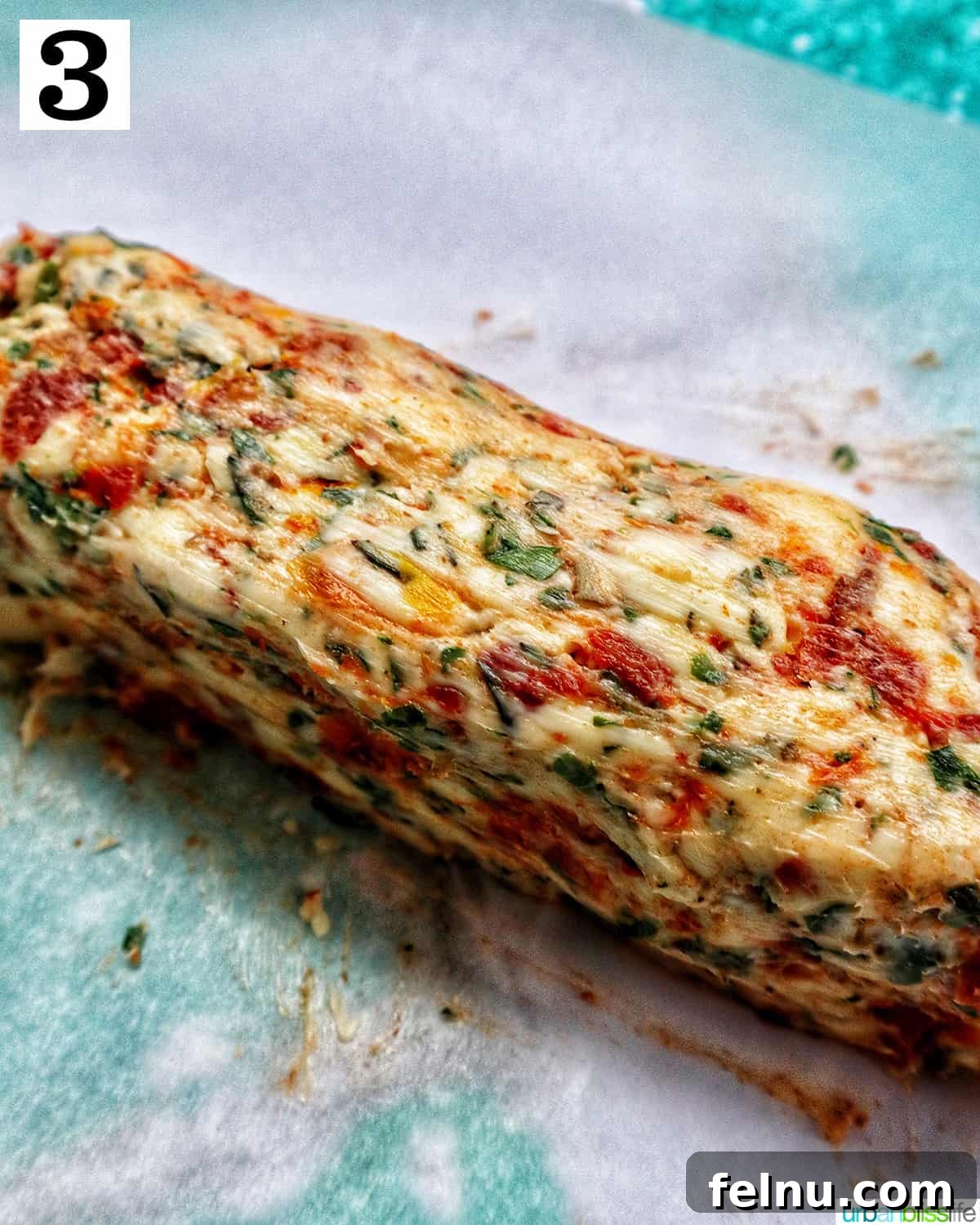 Sun-dried tomato compound butter log on parchment paper.