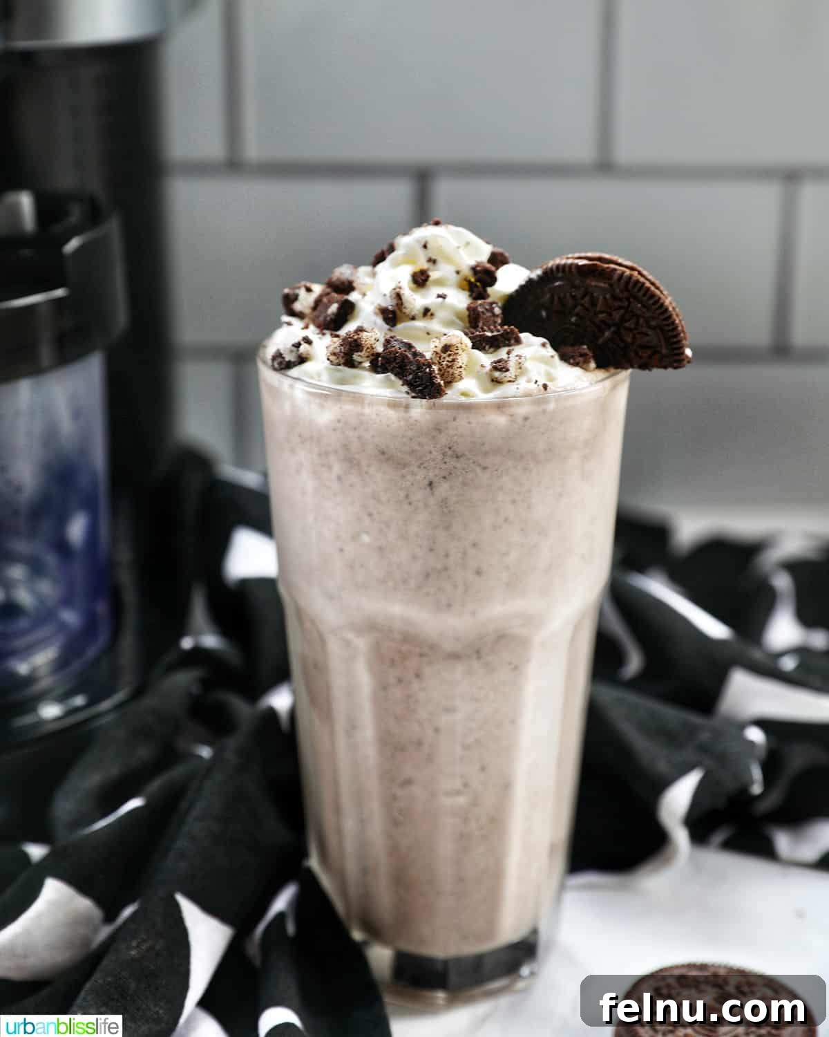 Creamy Dream: The 3-Ingredient Cookies and Cream Milkshake 2 A tall glass of Cookies & Cream Milkshake, topped generously with whipped cream and crushed Oreo cookies, sits invitingly.
