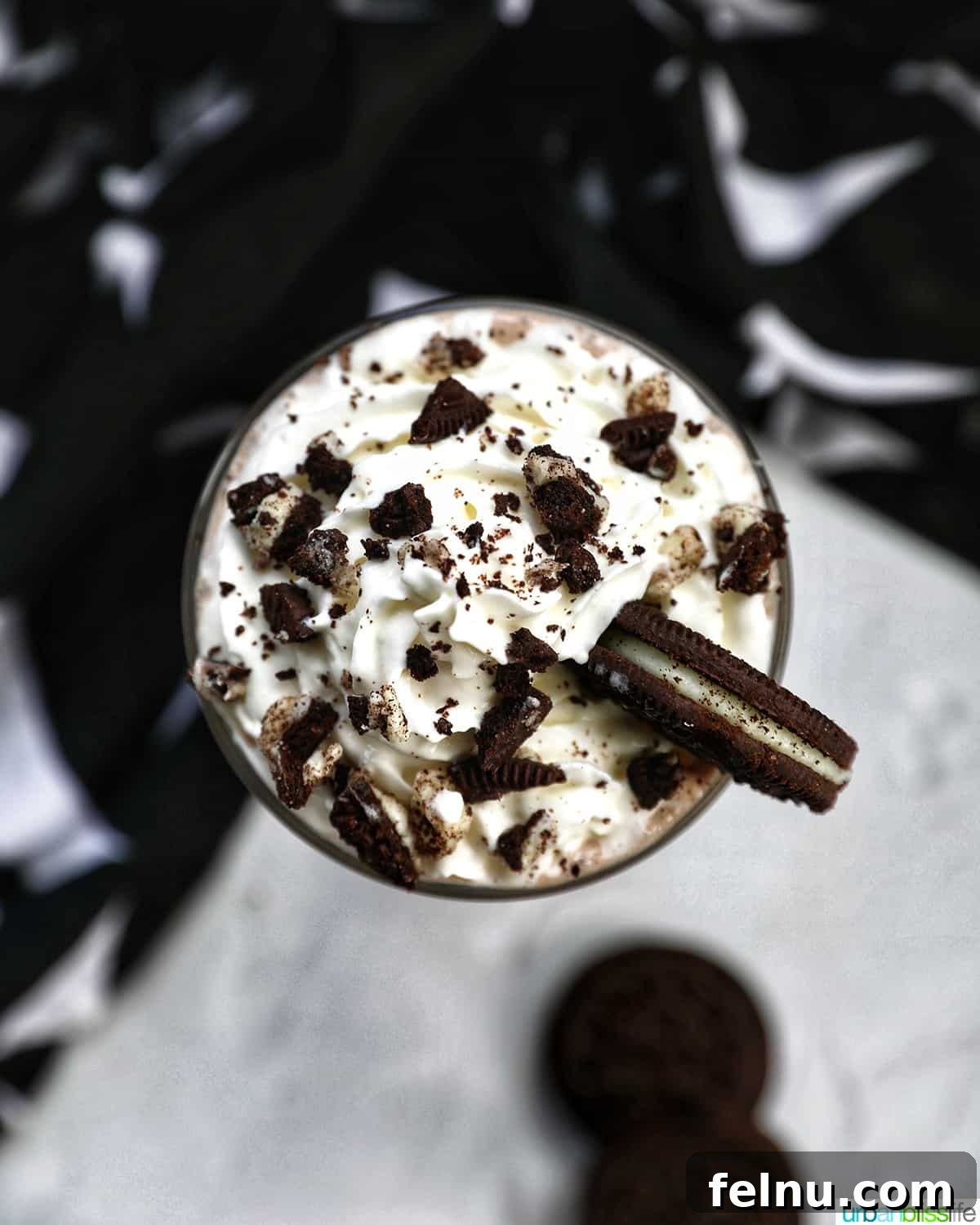 Creamy Dream: The 3-Ingredient Cookies and Cream Milkshake 5 Overhead photo of a Cookies & Cream Milkshake in a tall glass with whipped cream topping and crushed Oreo cookies, showcasing its delightful presentation.