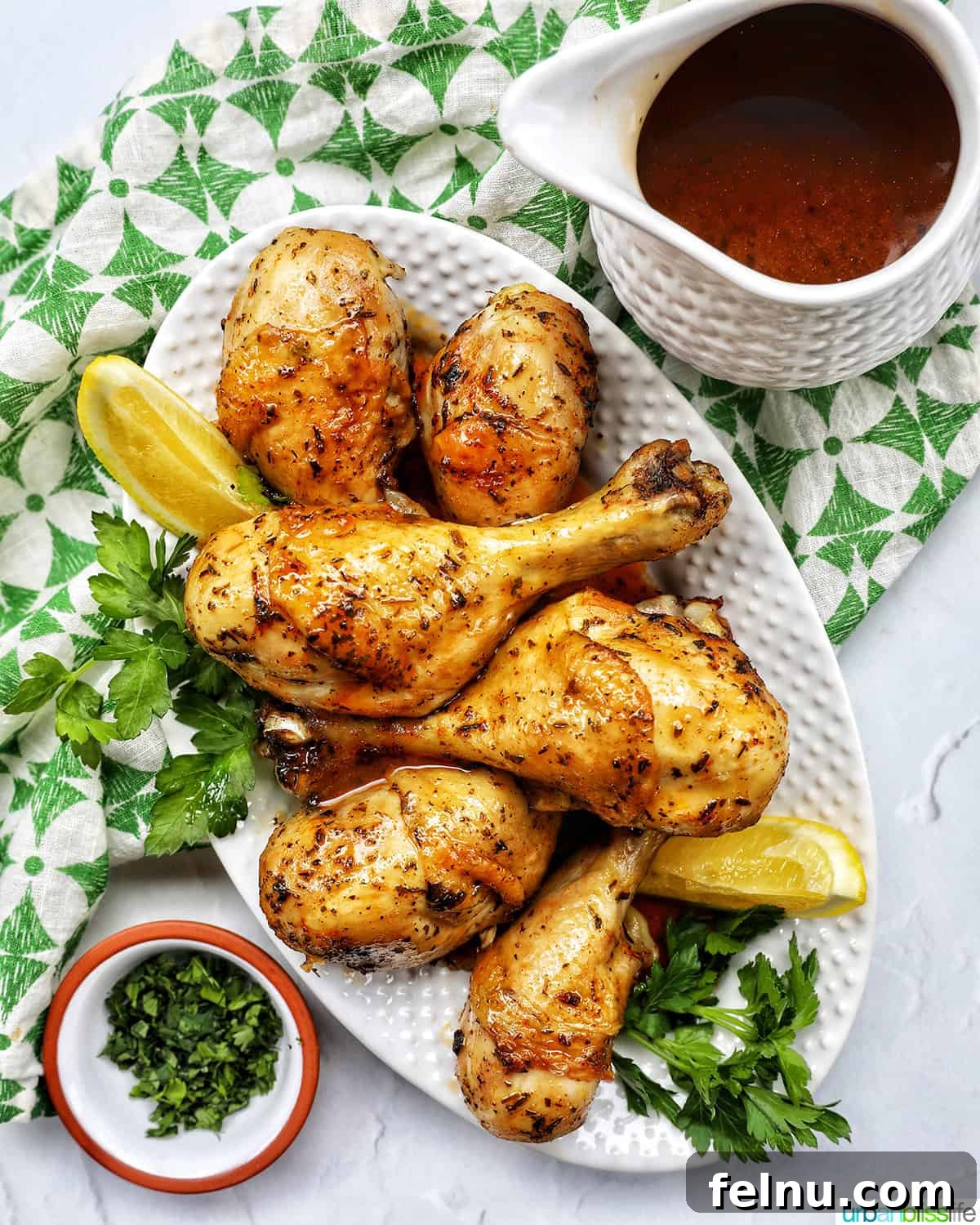 Instant Pot Chicken Legs 16 Instant Pot Chicken Drumsticks plated with gravy, parsley, and lemon wedges.