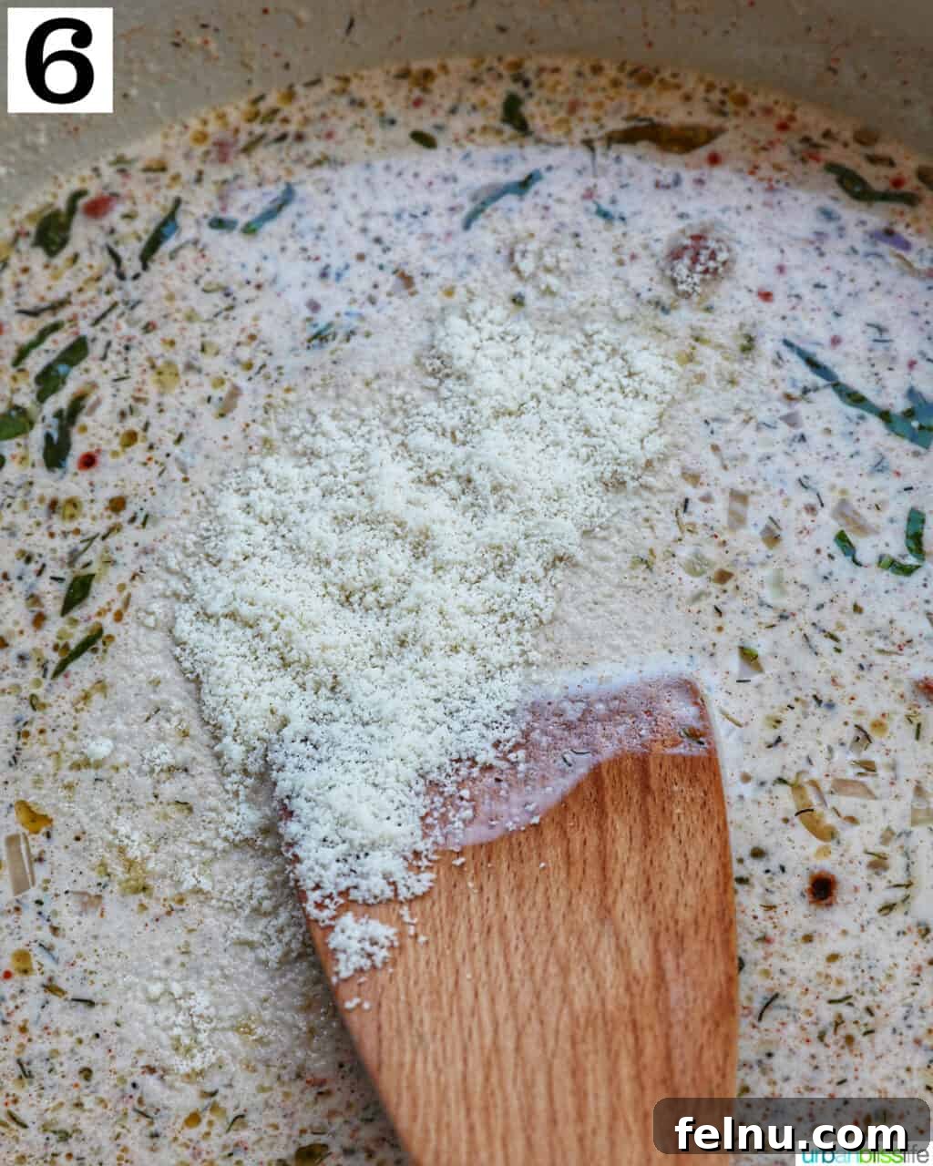 Melting Parmesan cheese into the cream sauce.