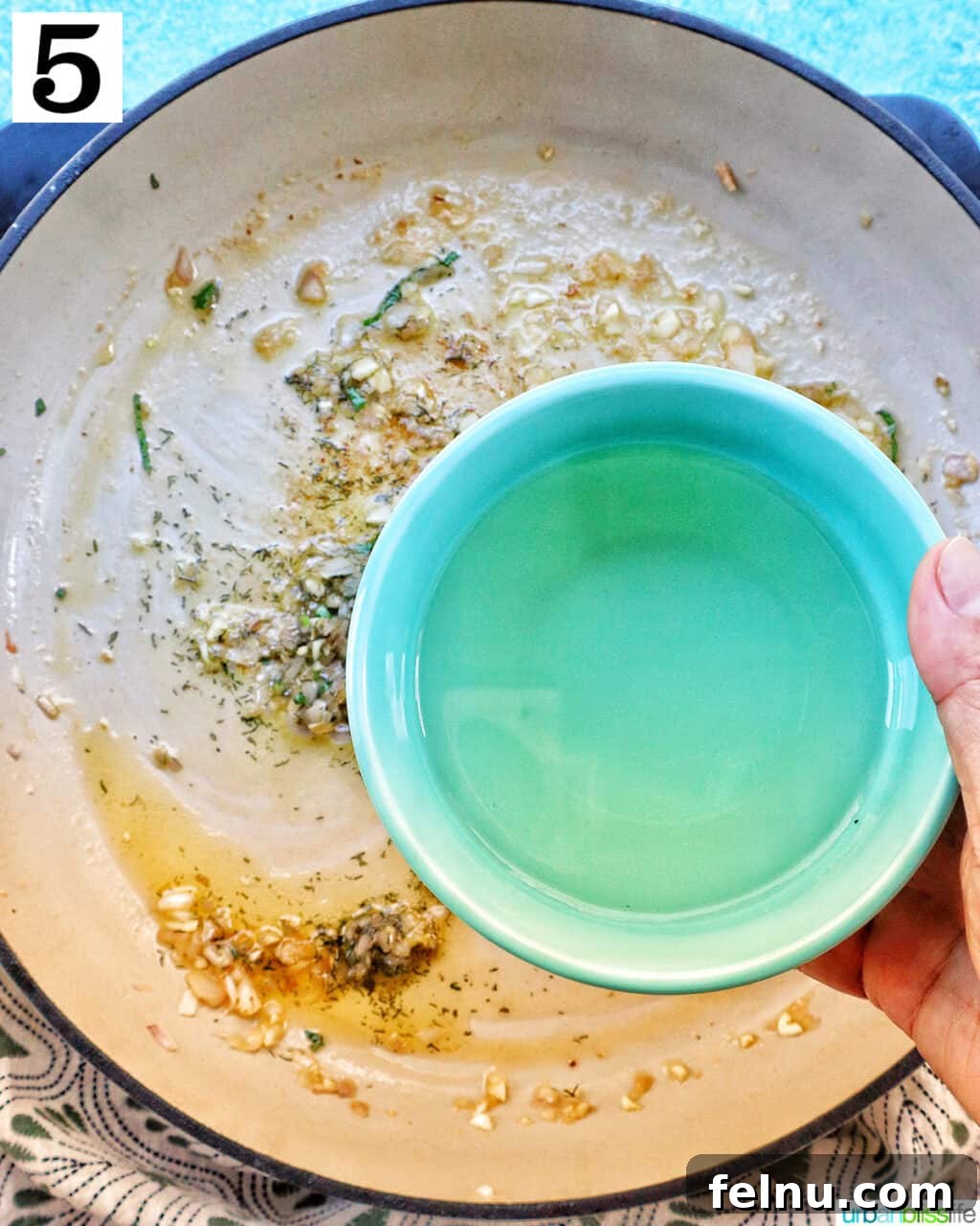 Pouring white wine into the pan.