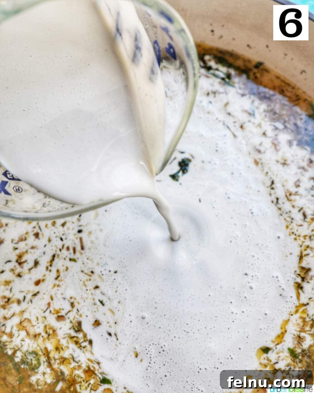Adding heavy cream to the sauce.