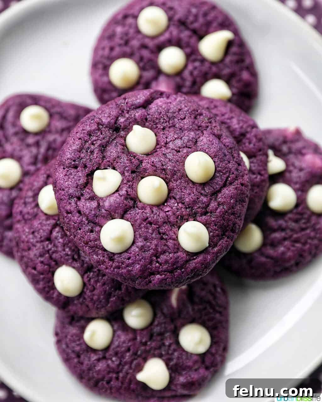 Dinner with the Jayme-Schotlands 15 A stack of vibrant Ube White Chocolate Chip Cookies on a pristine white plate, showcasing their unique purple hue and inviting texture.