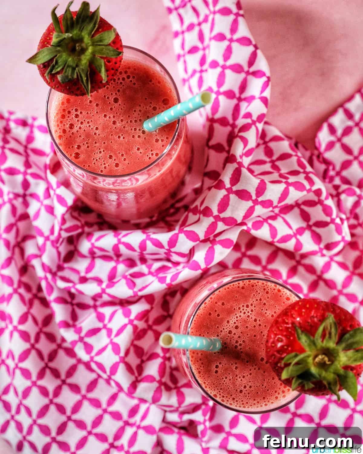Strawberry Watermelon Refresher 3 Overhead view of two strawberry watermelon smoothies garnished with fresh strawberries.