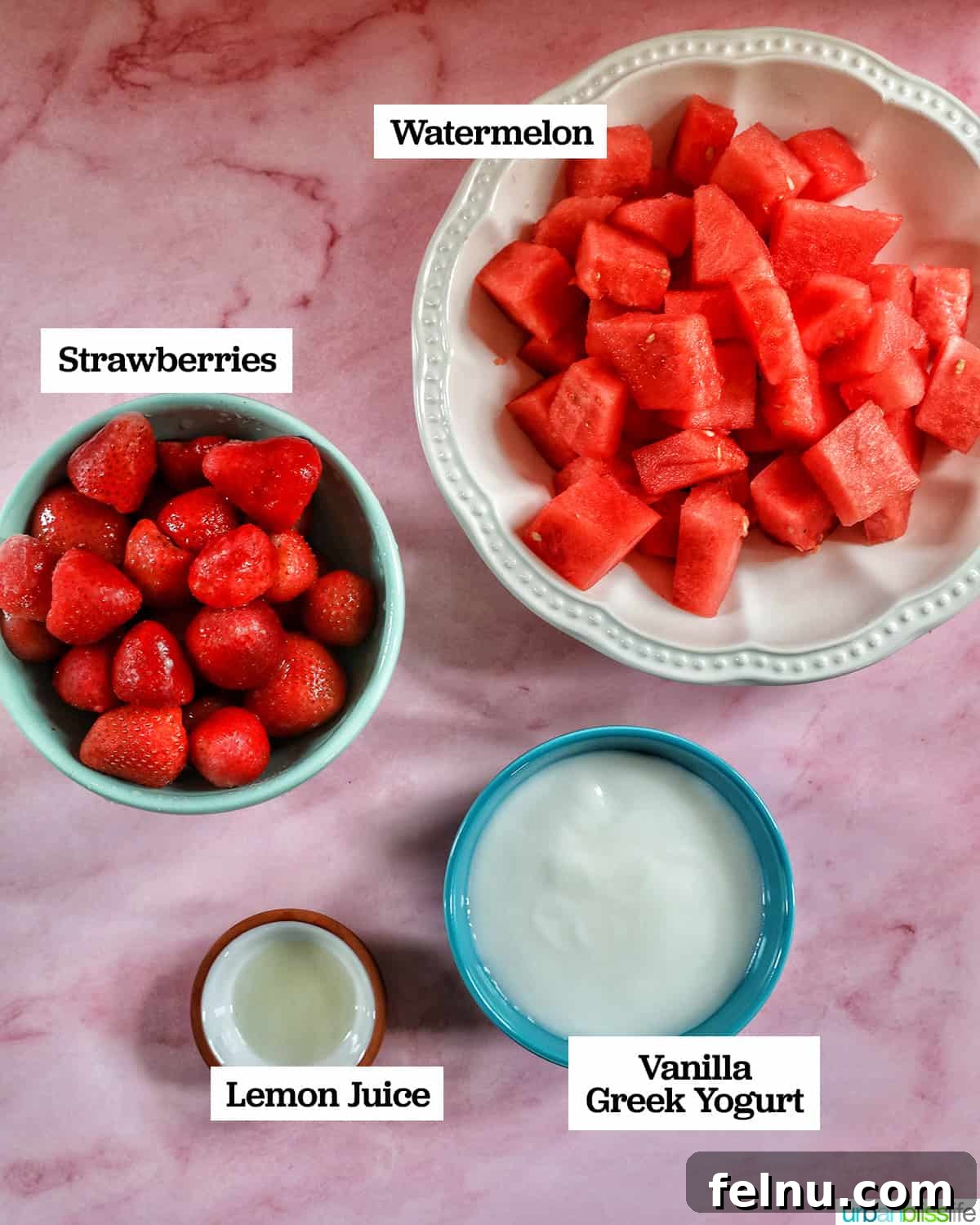 Strawberry Watermelon Refresher 4 Bowls of fresh strawberries, diced watermelon, and yogurt on a pink table.