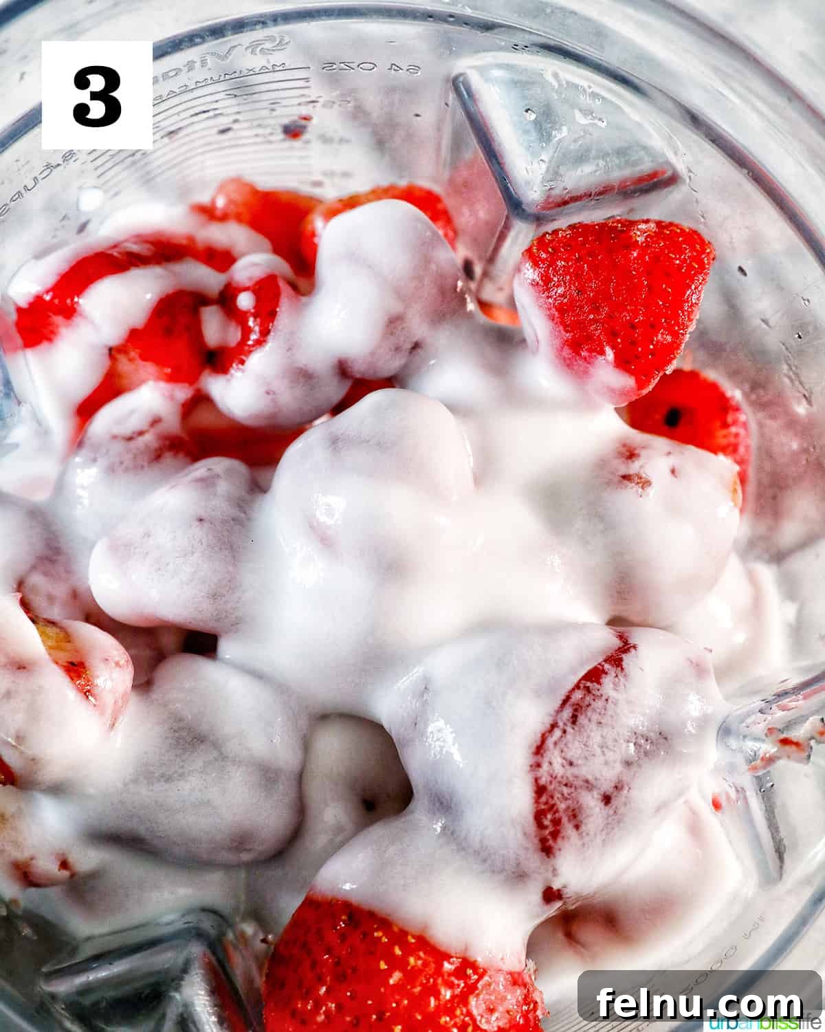 Strawberry Watermelon Refresher 7 Yogurt being added to strawberries and watermelon chunks in a blender.