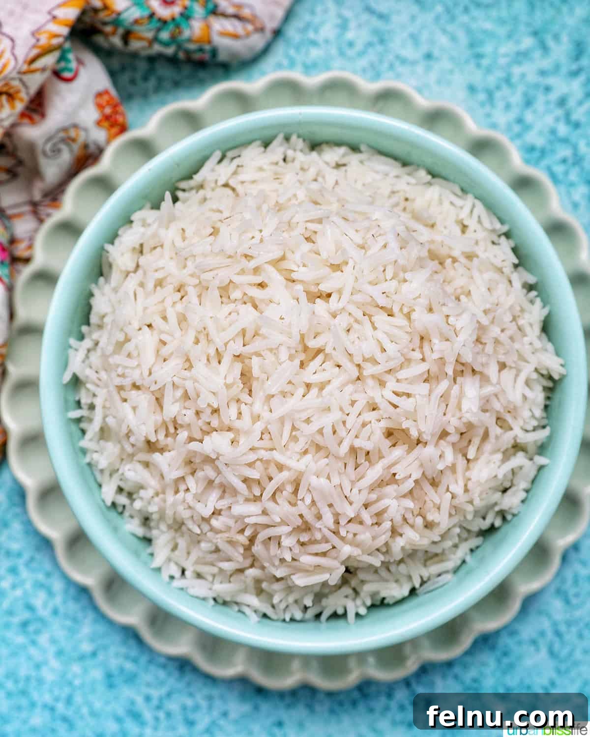 Fluffy Instant Pot Basmati Rice 2 white basmati rice in a blue bowl on green plate.