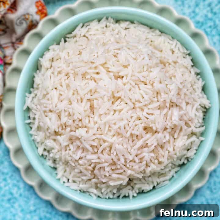 Fluffy Instant Pot Basmati Rice 10 white basmati rice in a blue bowl on green plate.