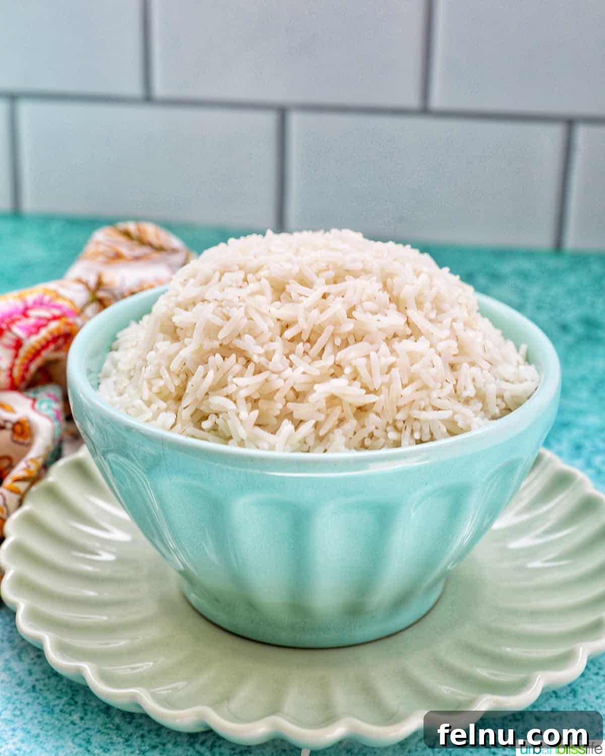 Fluffy Instant Pot Basmati Rice 3 white basmati rice in a blue bowl on green plate.