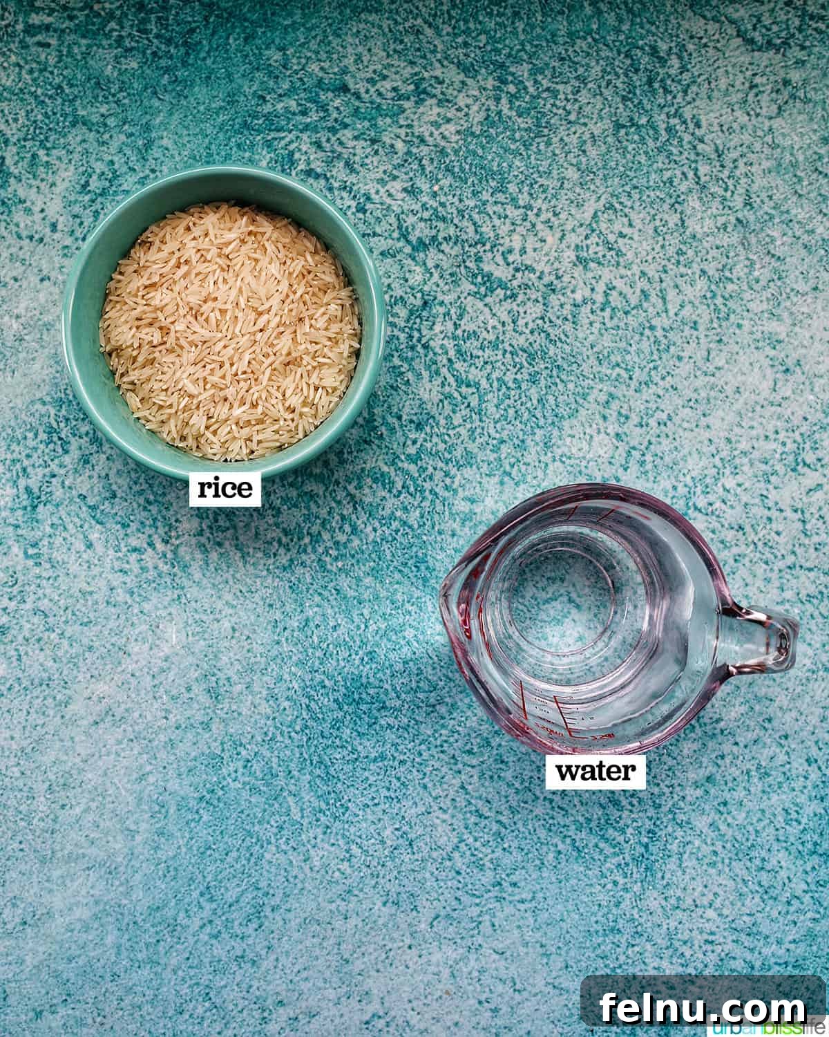Fluffy Instant Pot Basmati Rice 4 basmati rice in a blue bowl next to a pyrex measuring cup of water on a blue background.