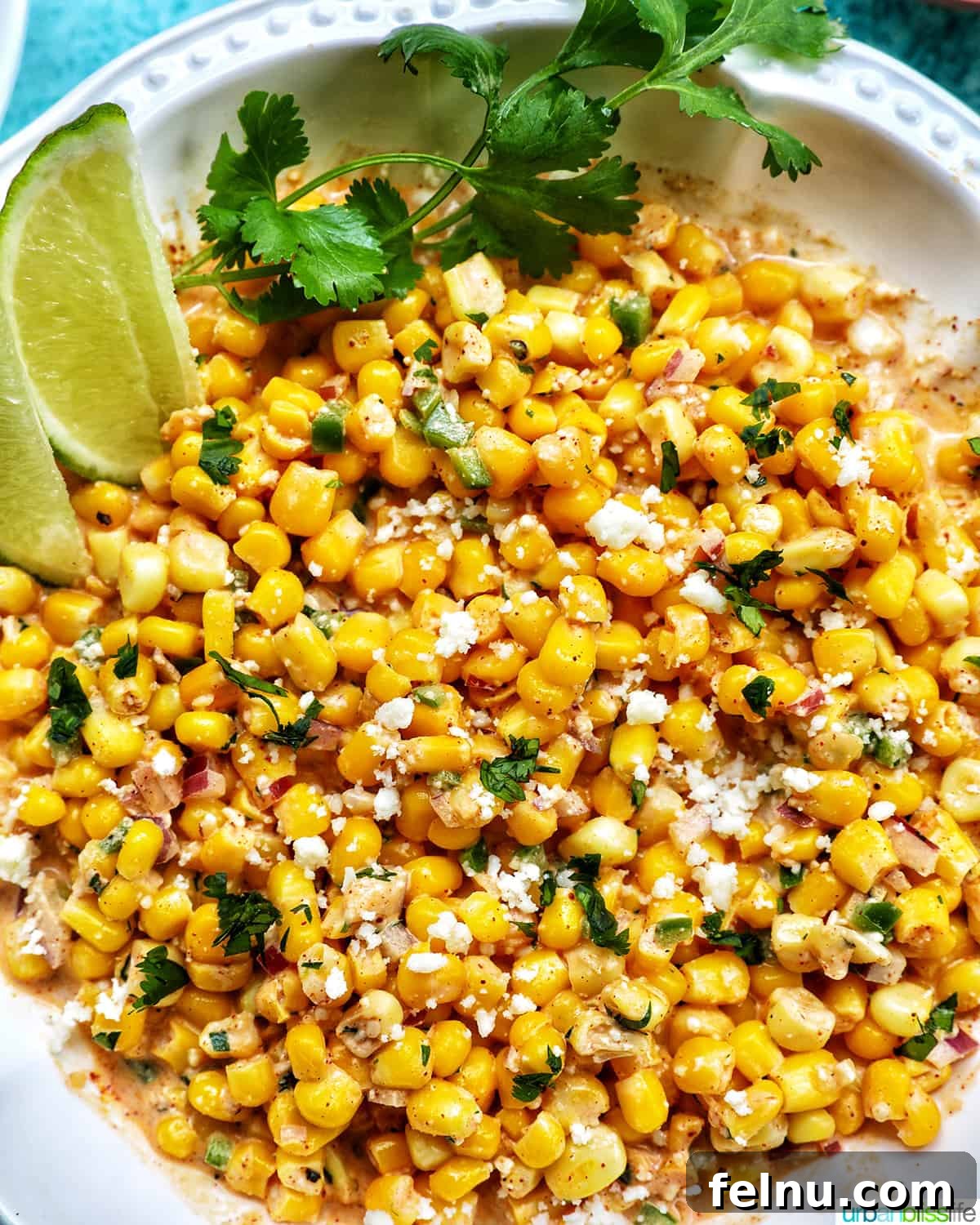 Mexican Street Corn Fiesta Dip 2 Big bowl of creamy Mexican Elote Dip, garnished with fresh cilantro and lime wedges, ready to be scooped with tortilla chips.