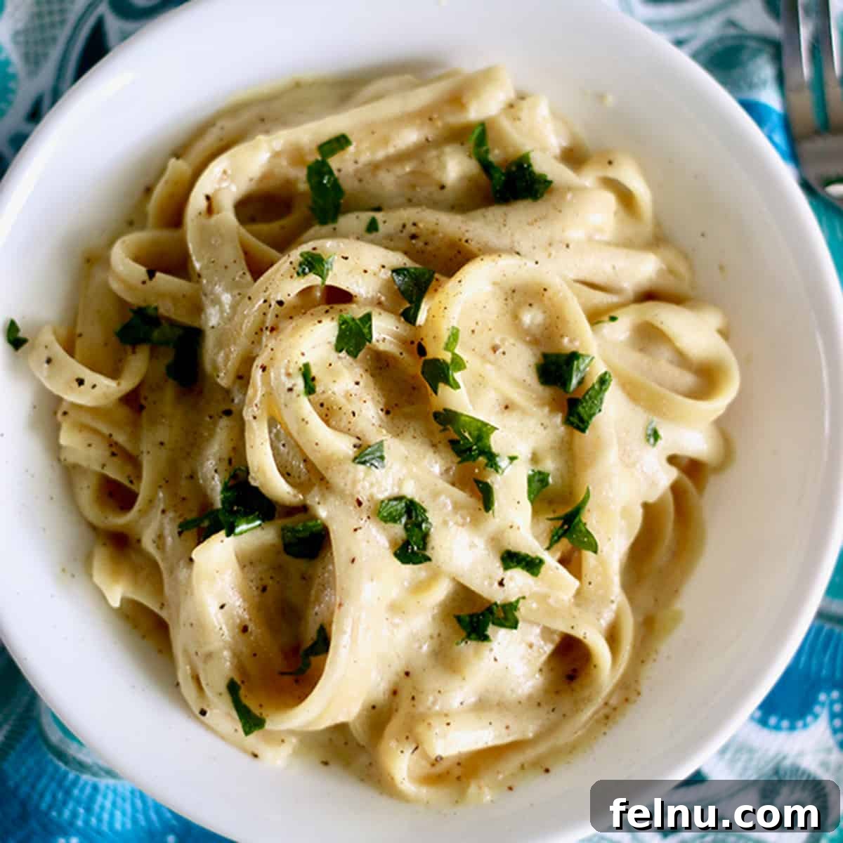 Uncorking Pasta Perfection 9 dairy free fettuccine alfredo topped with parsley.