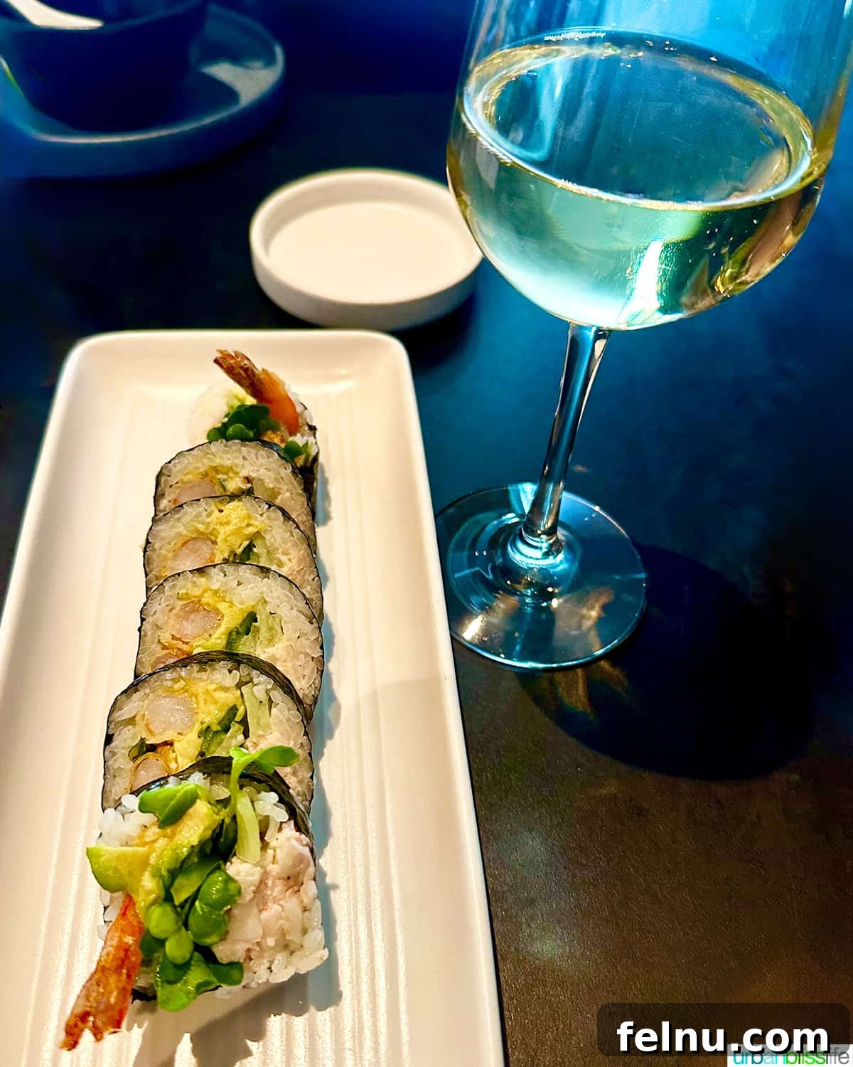 Wine's Dance with Sushi: A Culinary Harmony 4 A glass of white wine alongside a plate of sushi rolls, demonstrating the elegance of white wine and sushi pairings.