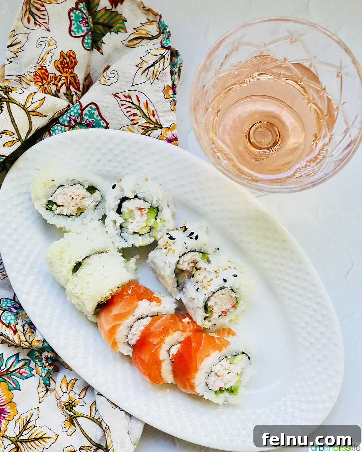 Wine's Dance with Sushi: A Culinary Harmony 5 A glass of rosé wine with a plate of sushi rolls, showcasing the vibrant flavors and colors of rosé and sushi.