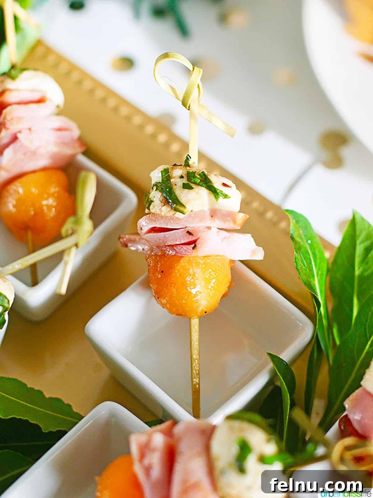 Elevate Your Ham with the Perfect Wine 3 ham, melon, and mozzarella bites on skewers.