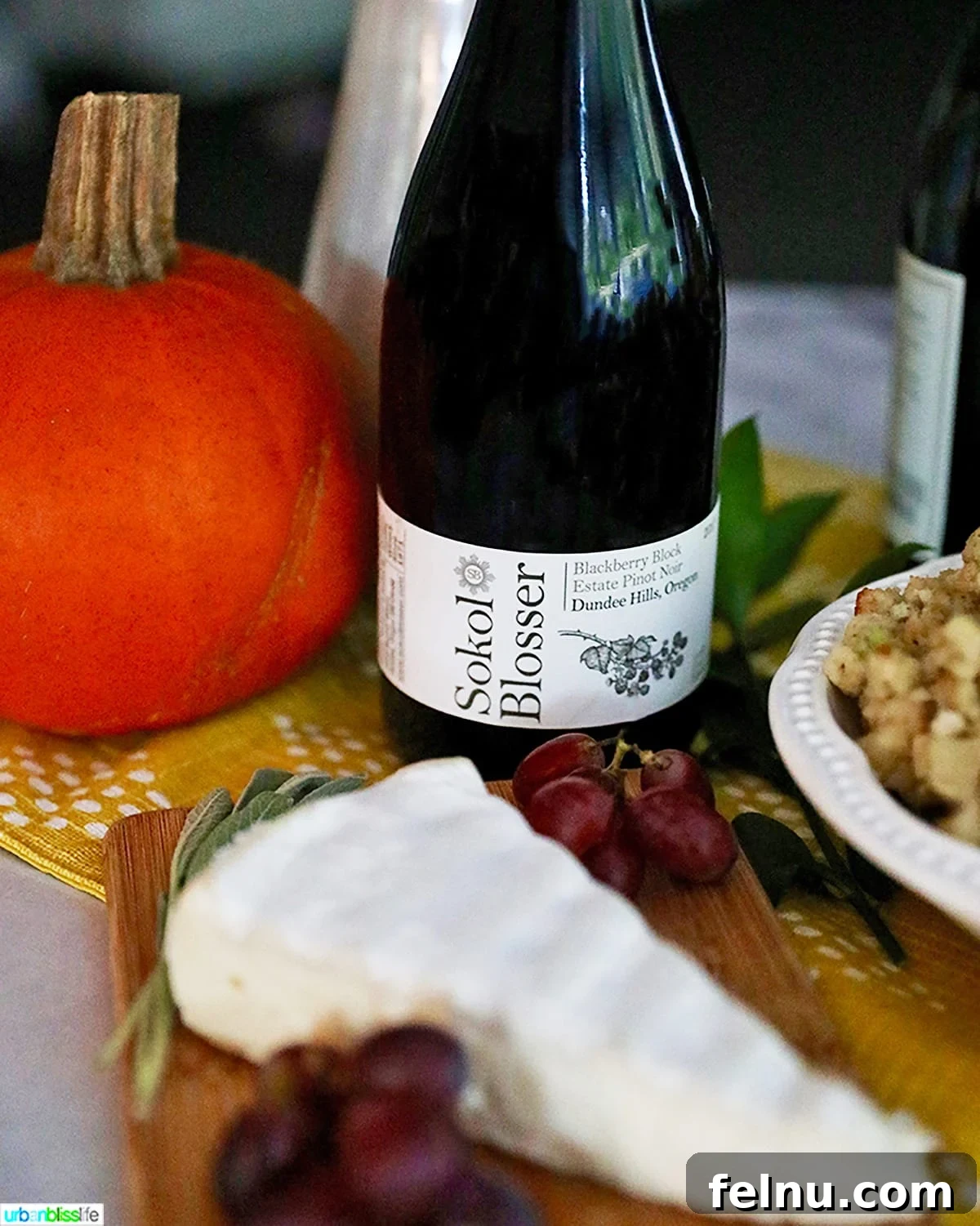 The Perfect Pairing: Wine and Turkey 8 A bottle of wine displayed on a table alongside brie cheese, pumpkin, and stuffing.