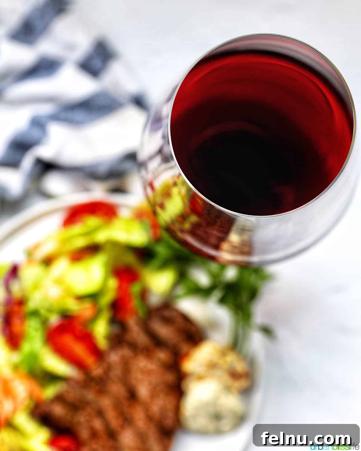 The Art of Steak and Wine Pairing 3 A perfectly seared steak, accompanied by a fresh salad, alongside a glistening glass of rich red wine, illustrating a harmonious meal.