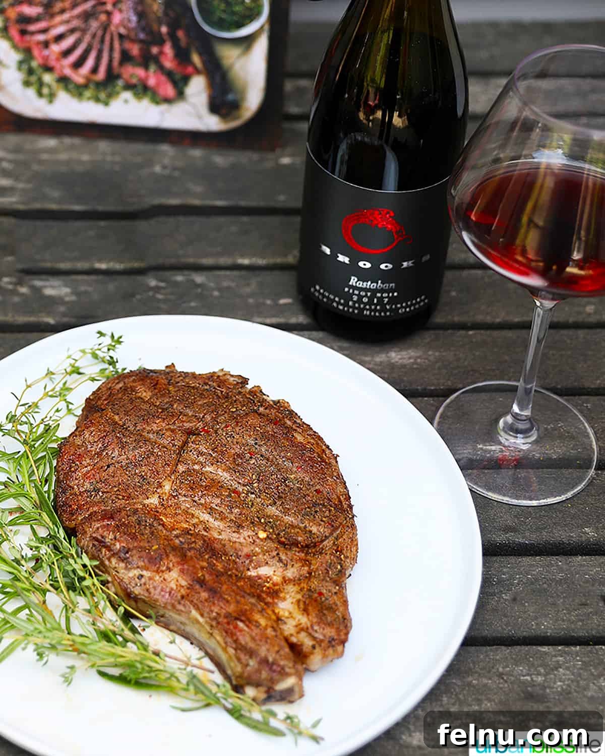 The Art of Steak and Wine Pairing 5 A bottle and glass of rich red wine set elegantly beside a plate adorned with a perfectly cooked steak and fresh herbs, symbolizing the perfect pairing.