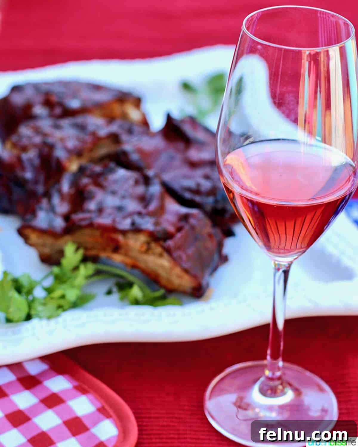 The Art of Steak and Wine Pairing 6 A refreshing glass of rosé wine beautifully juxtaposed with a plate of succulent grilled steak ribs, highlighting a perfect summer pairing.