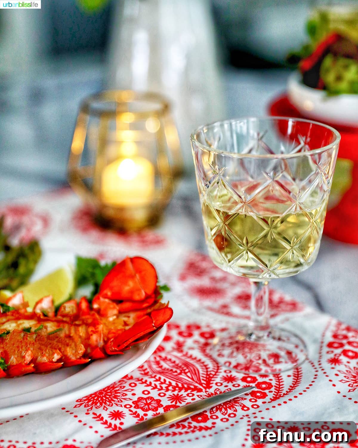 Chardonnay's Culinary Companions 11 A glass of white wine accompanies a succulent lobster tail, with a soft candle flame flickering in the background.