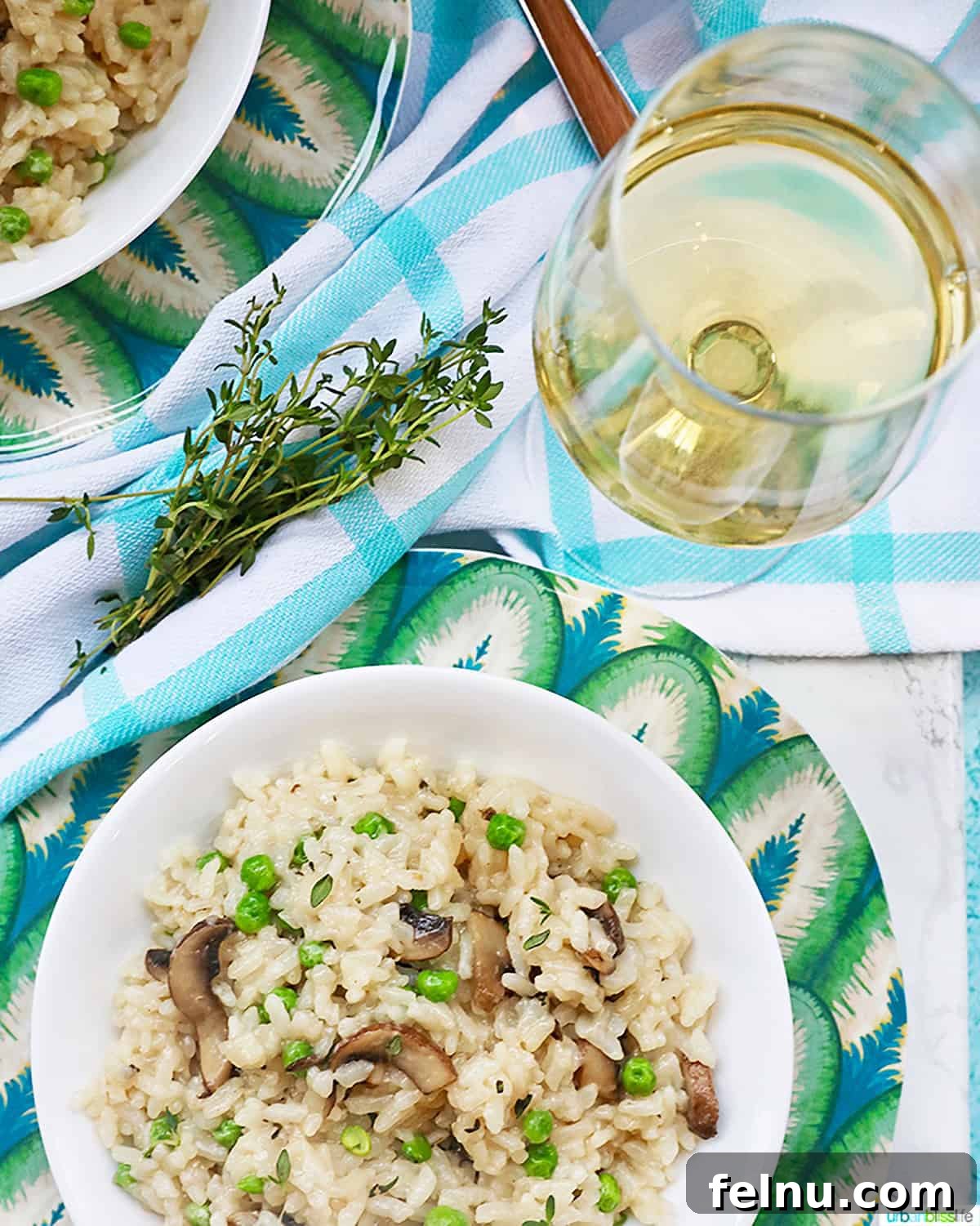 Chardonnay's Culinary Companions 12 A glass of white wine accompanies a heartwarming bowl of mushroom risotto, presented in a delightful flat lay.