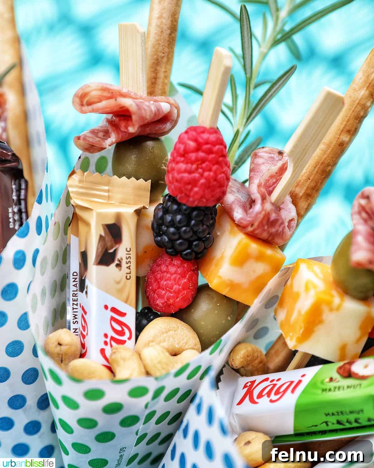 Charcuterie on the Go 2 Charcuterie cones filled with fruit, cheeses, breadsticks, nuts, chocolate, and herbs.