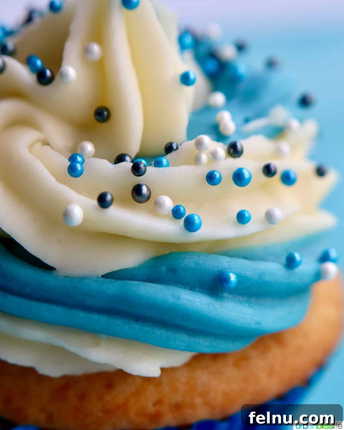 Effortless Vanilla Bean Buttercream 3 Vanilla cupcakes with blue and white buttercream frosting
