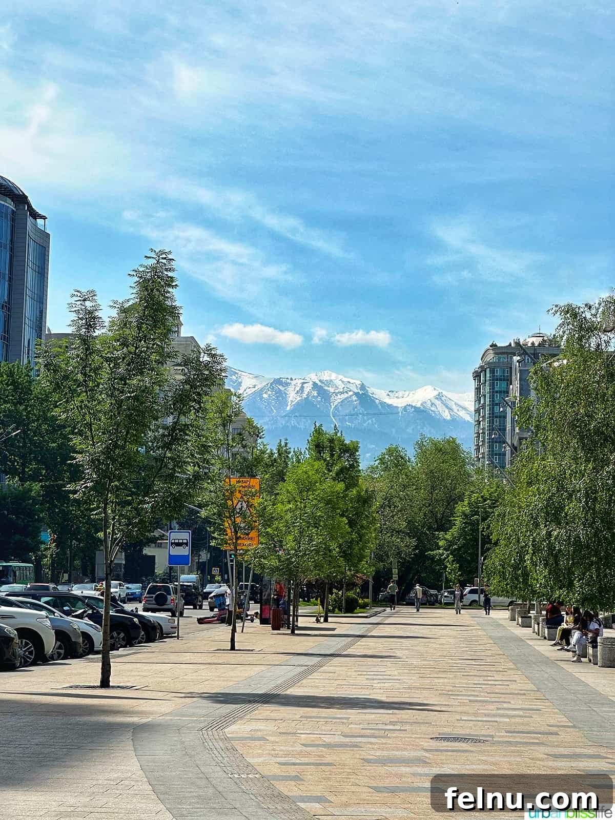 Explore Almaty: Thirty Unforgettable Things to Do 2 Almaty city street with majestic mountains forming a stunning backdrop, inviting travelers to explore the city's natural beauty and urban charm.