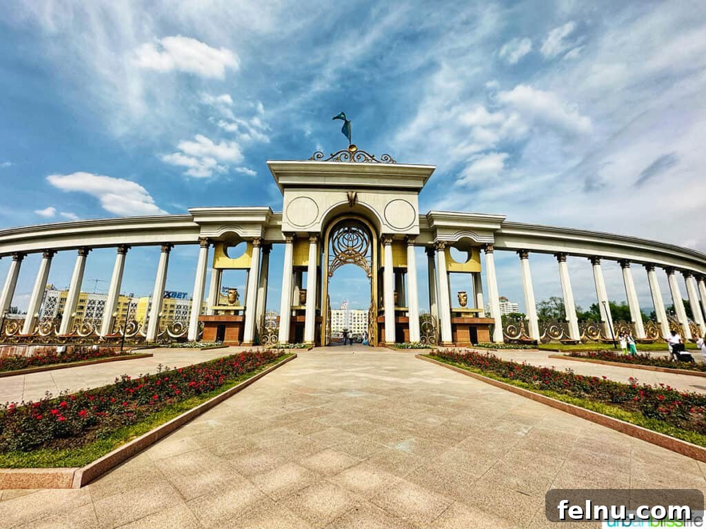 Explore Almaty: Thirty Unforgettable Things to Do 14 The grand arched entrance gate of First President's Park in Almaty, Kazakhstan, inviting visitors into its serene landscape.