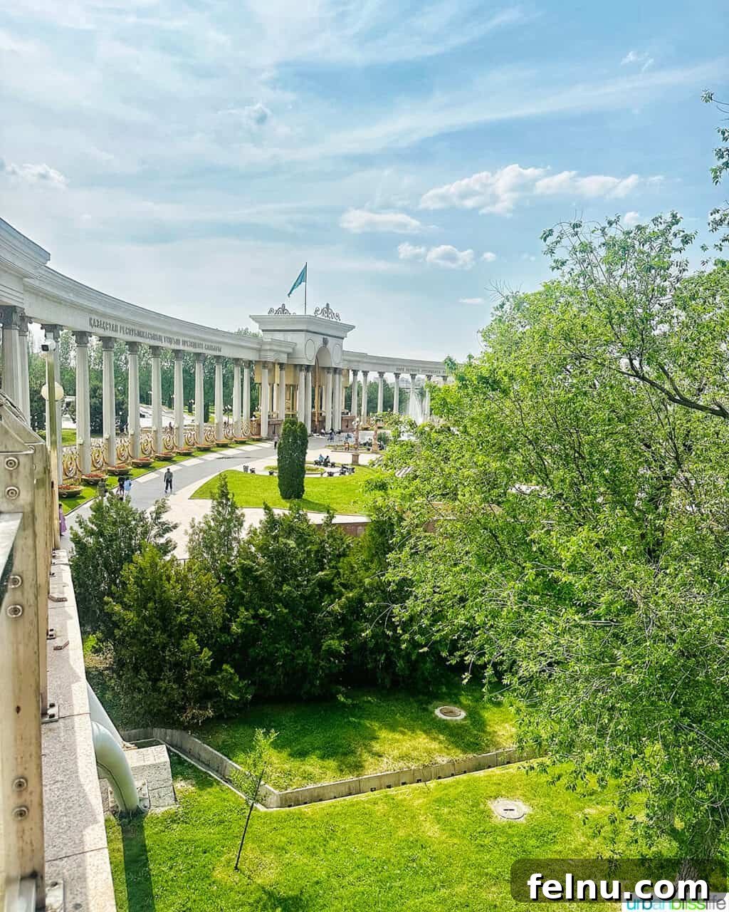 Explore Almaty: Thirty Unforgettable Things to Do 15 Lush, mature trees line the pathways of First President's Park in Almaty, Kazakhstan, creating a tranquil setting.