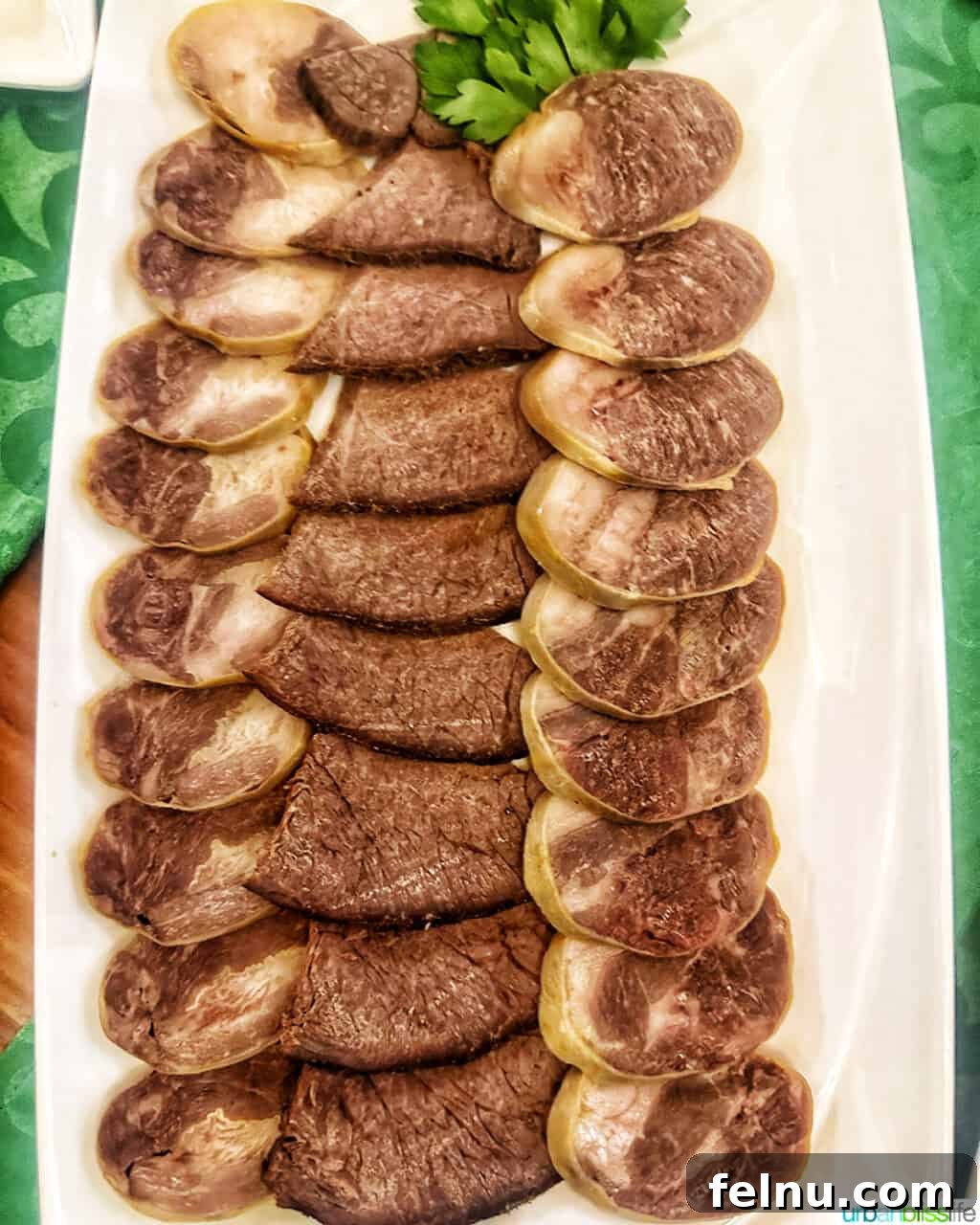 Explore Almaty: Thirty Unforgettable Things to Do 17 A white platter generously filled with kazy, a traditional boiled horse meat sausage, sliced and ready to be served—a popular dish in Kazakhstan.
