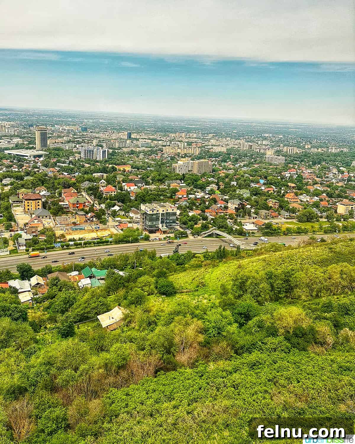 Explore Almaty: Thirty Unforgettable Things to Do 3 view of Almaty city from the gondola cable car up Kok Tobe hill, showcasing the urban landscape against a mountain backdrop.