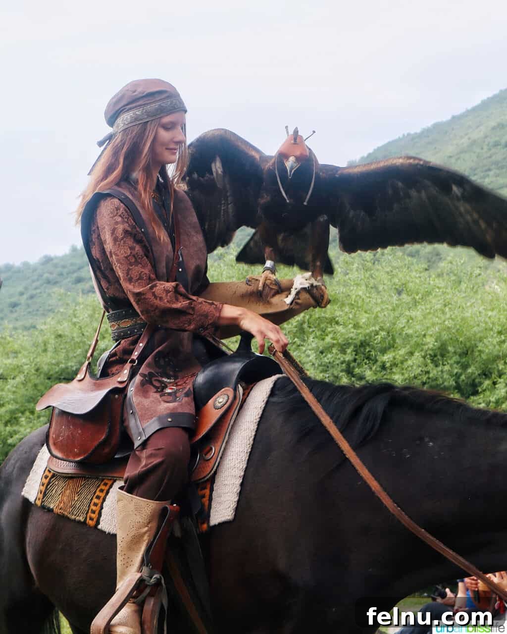 Explore Almaty: Thirty Unforgettable Things to Do 22 A skilled falcon trainer holds a large majestic falcon on her arm while riding horseback at Falcon Farm Sunkar near Almaty, Kazakhstan.