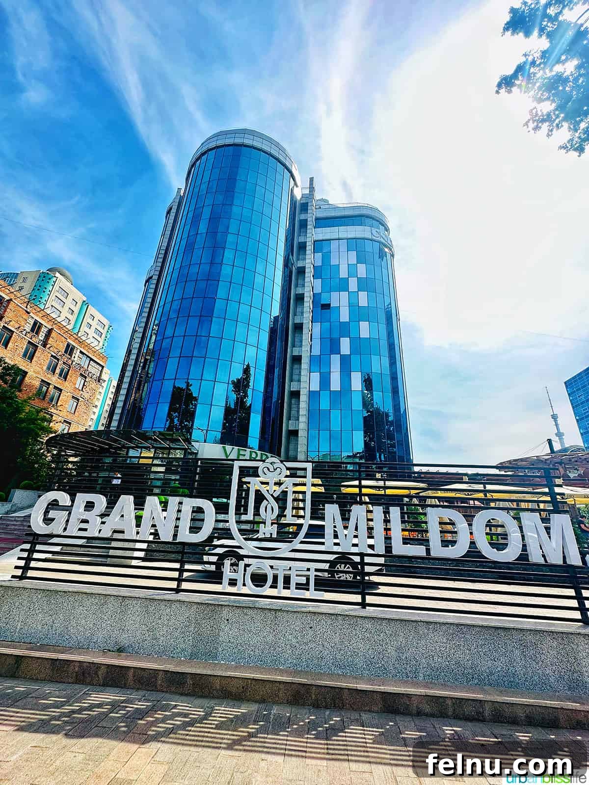 Explore Almaty: Thirty Unforgettable Things to Do 4 The impressive front exterior and welcoming sign of the Grand Mildom Hotel in Almaty, Kazakhstan, suggesting a luxurious and comfortable stay.