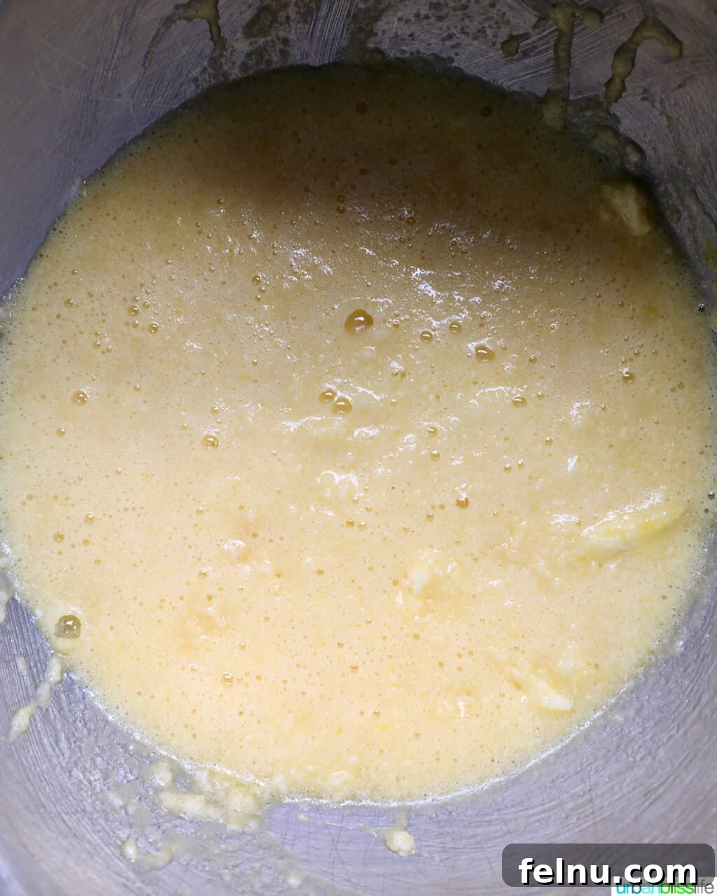 Smooth and creamy cake batter in a stainless steel mixing bowl.
