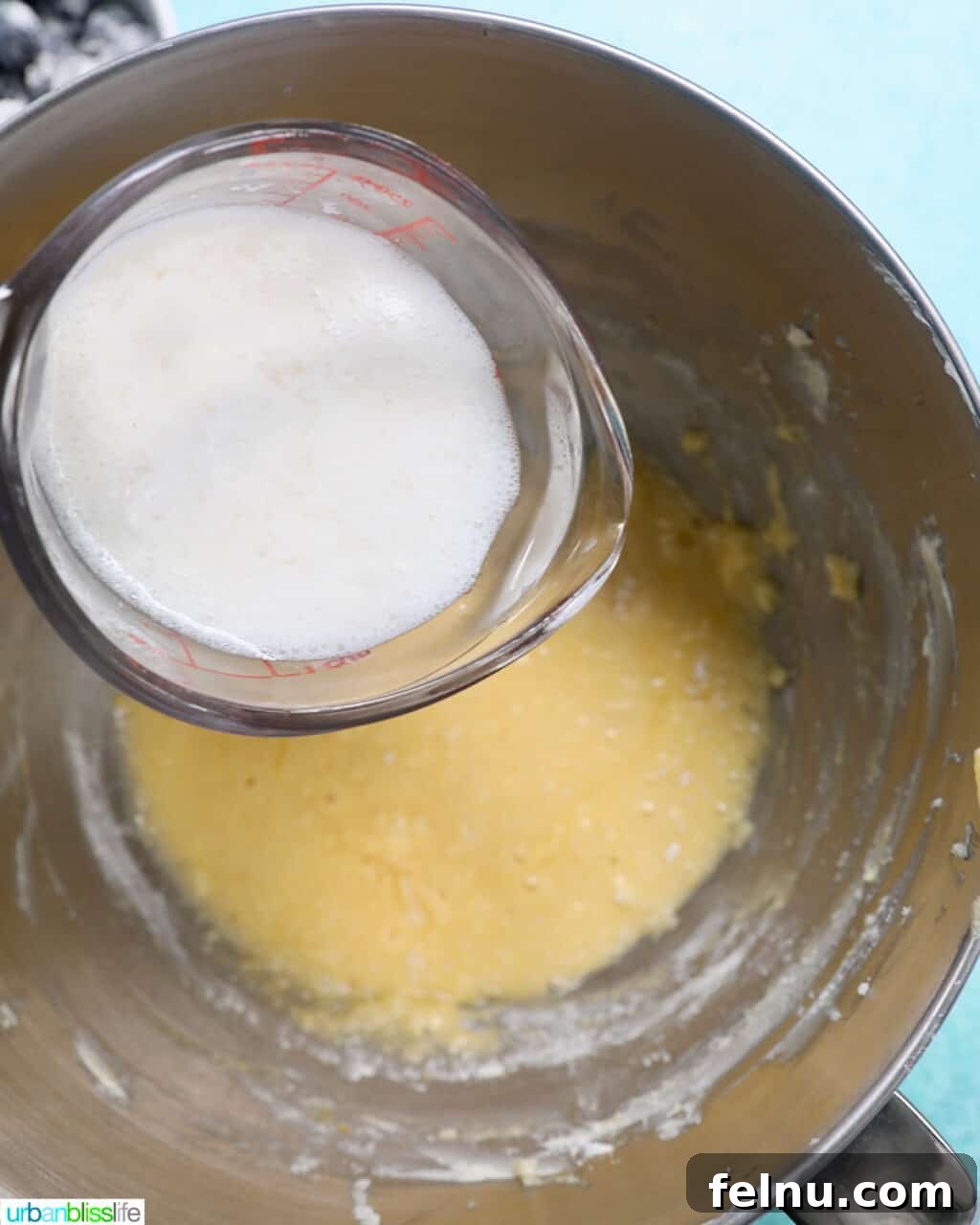 Buttermilk being poured into the cake batter.