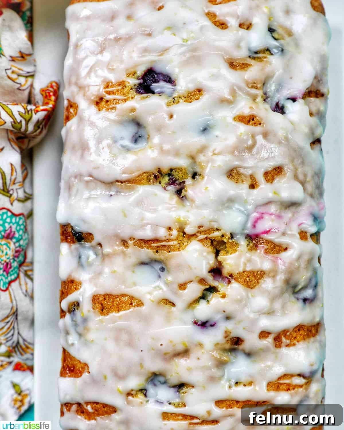 Overhead view of a lemon blueberry pound cake with a generous drizzle of lemon glaze.