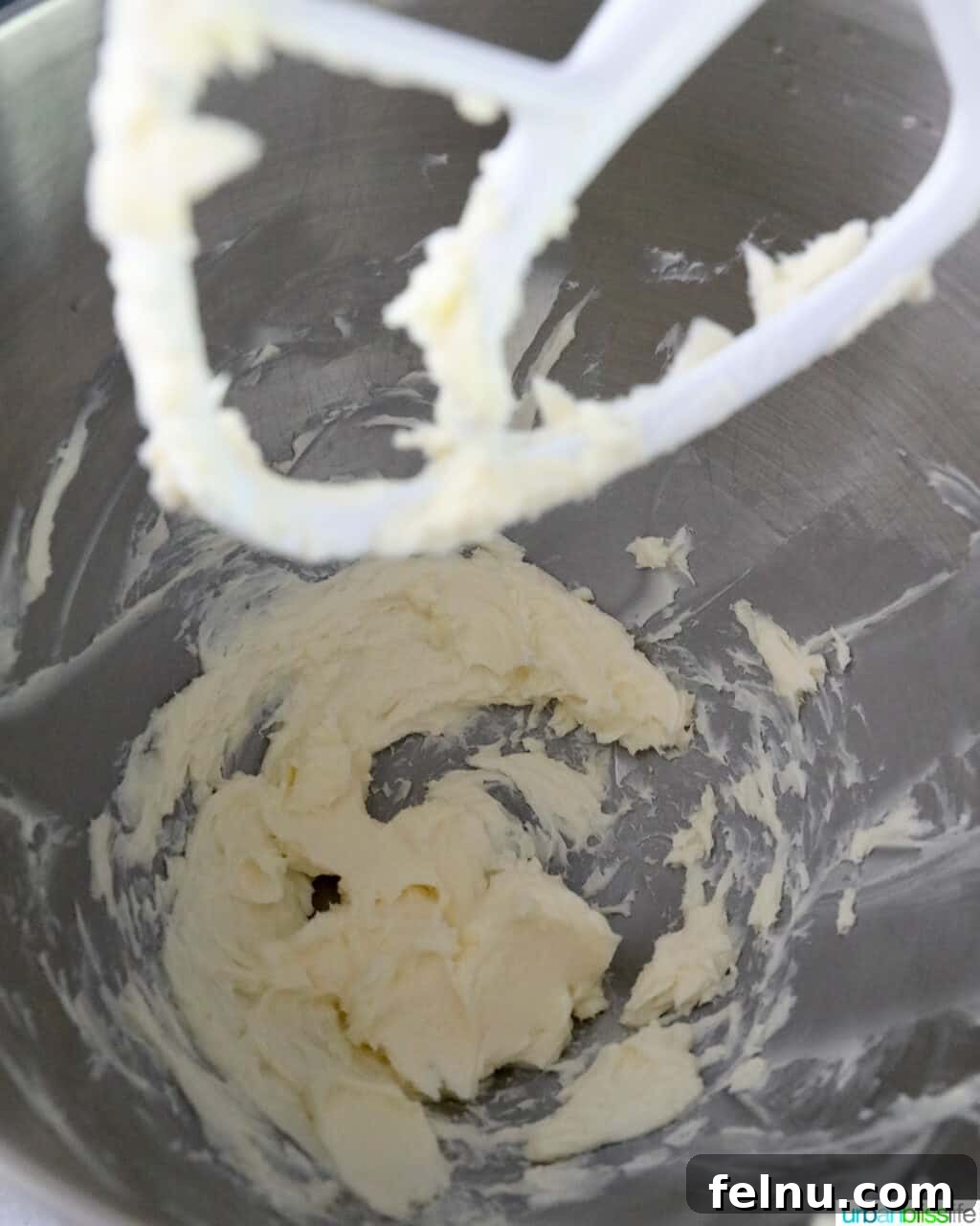Creamed butter in a stainless steel stand mixer bowl, using the paddle attachment.