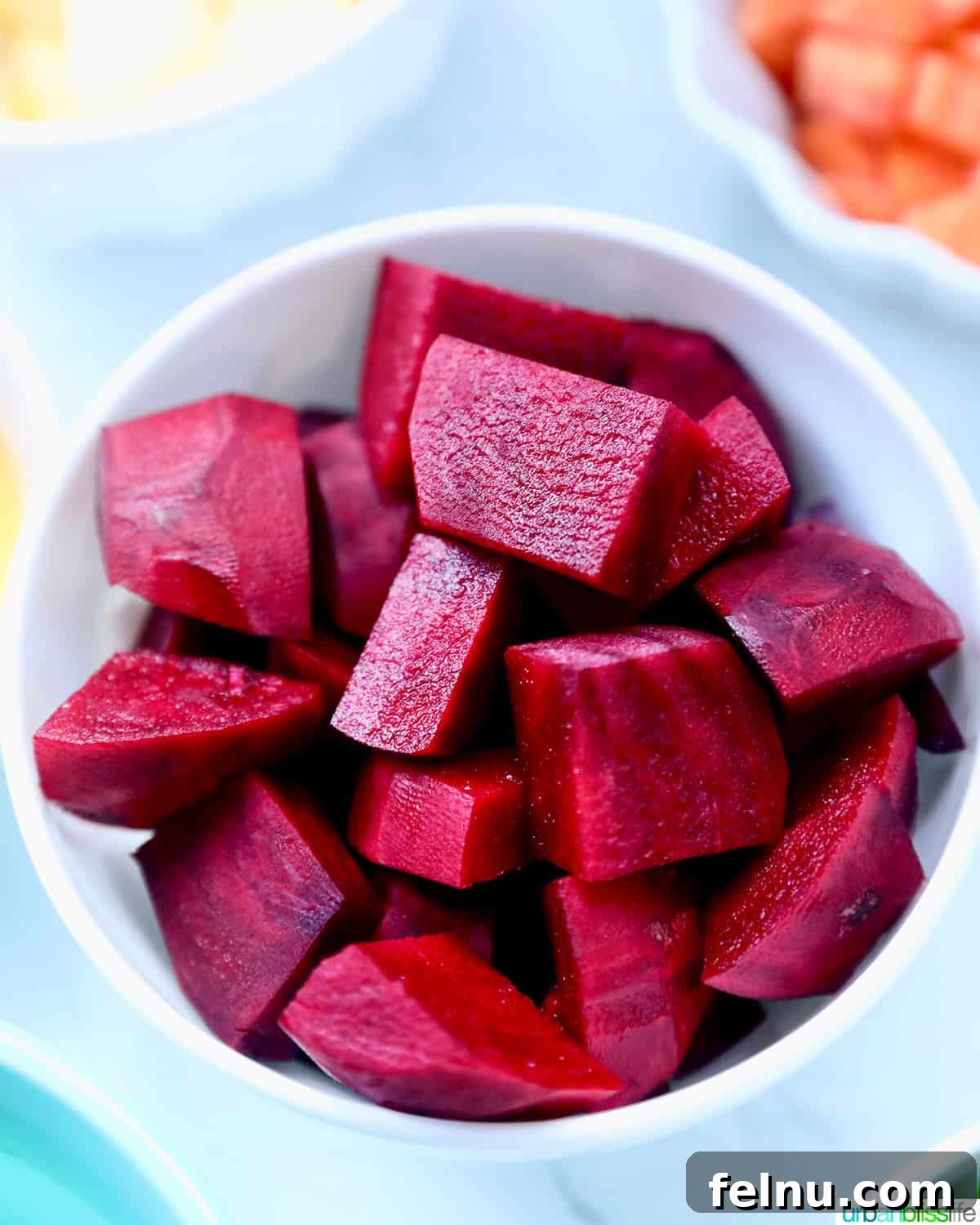 Ruby Root Revival 4 chopped red beets in a white bowl.