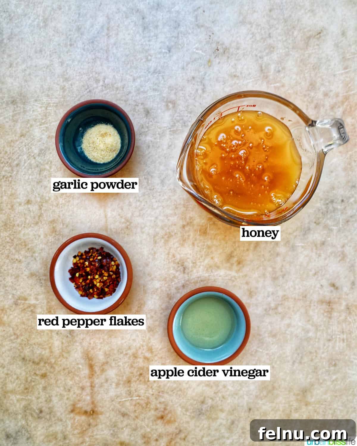 Bowls filled with the four simple ingredients needed to make Hot Honey Sauce.