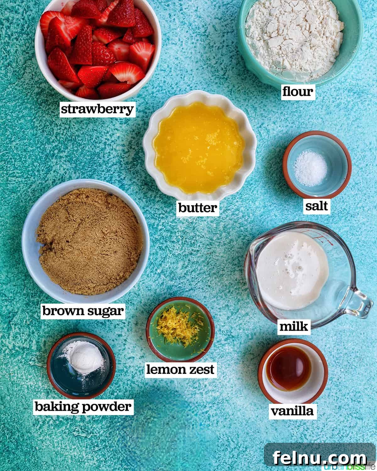 Bowls of ingredients for Strawberry Spoon Cake on a blue table.