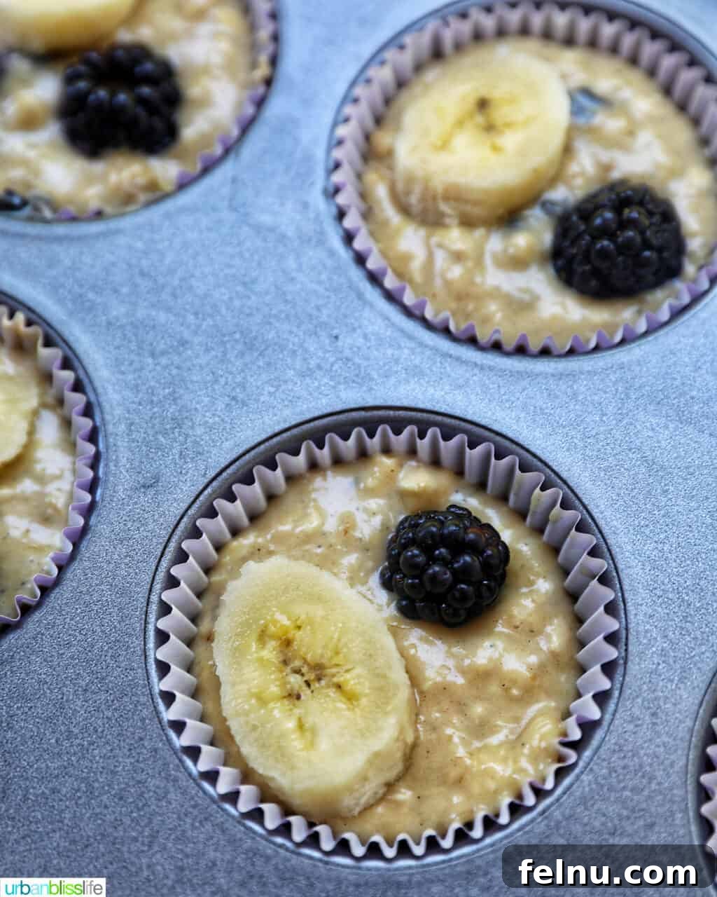 Bursting Blackberry Banana Oat Muffins 14 Muffin batter evenly distributed into lined muffin cups within a tin, ready for baking.