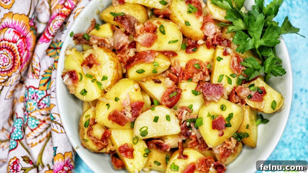 Creamy Baby Potato Salad with Crispy Bacon 12 landscape photo of a bowl of baby potato salad with bacon with colorful napkin