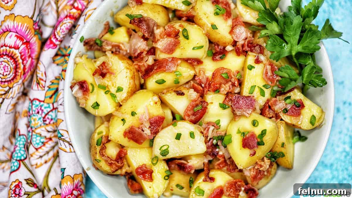 Creamy Baby Potato Salad with Crispy Bacon 14 landscape photo of a bowl of baby potato salad with bacon with colorful napkin