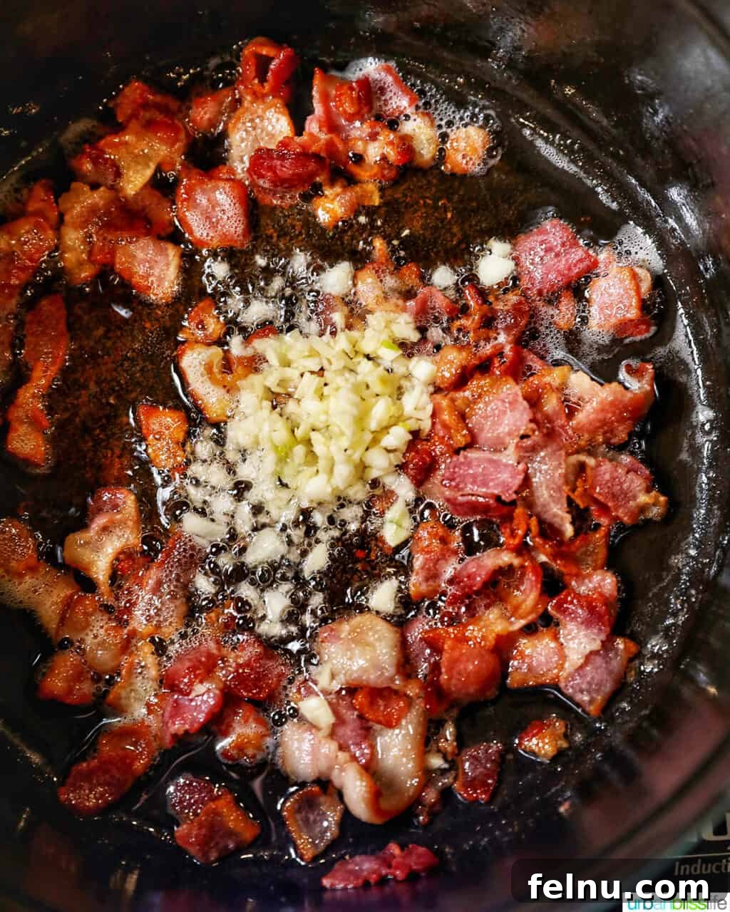 Creamy Baby Potato Salad with Crispy Bacon 7 adding minced garlic to cooked bacon in a pan