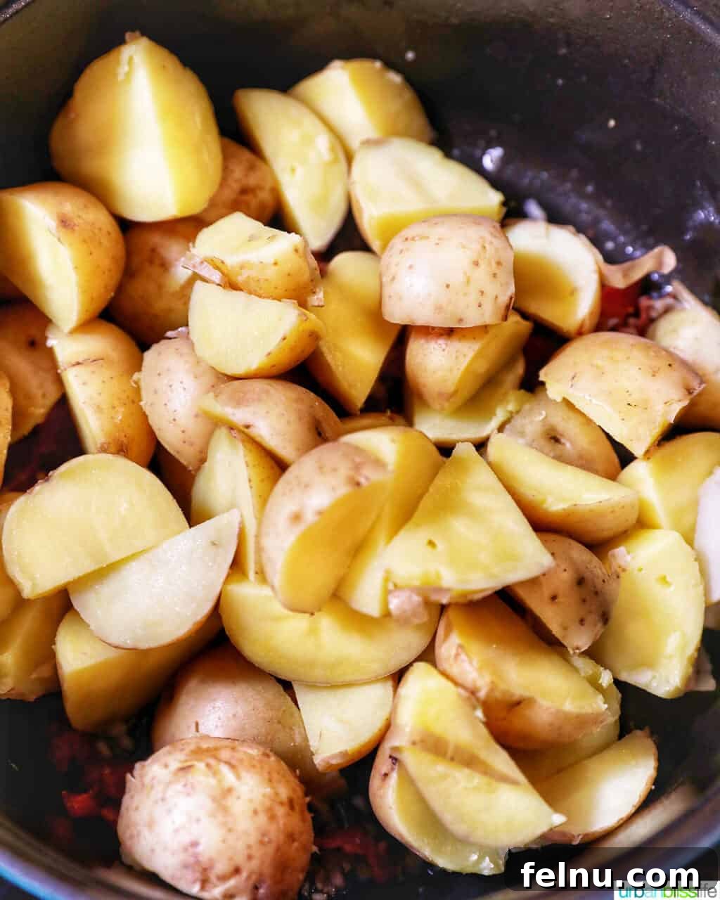 Creamy Baby Potato Salad with Crispy Bacon 9 adding cut potatoes to the pot with bacon and garlic