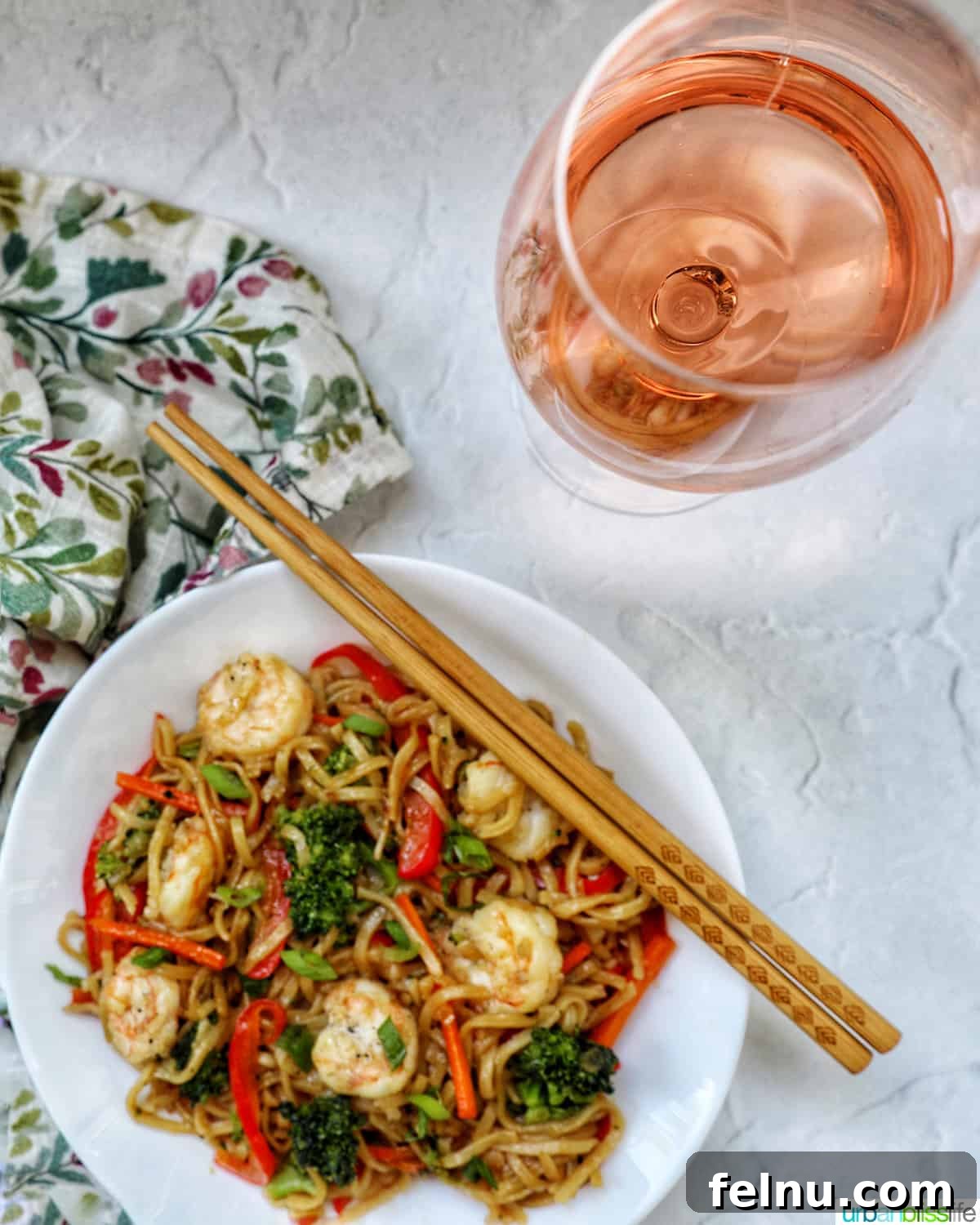 Homemade Prawn Chow Mein Delight 20 A bowl of Prawn Chow Mein next to a glass of chilled rosé wine, suggesting a perfect meal pairing.