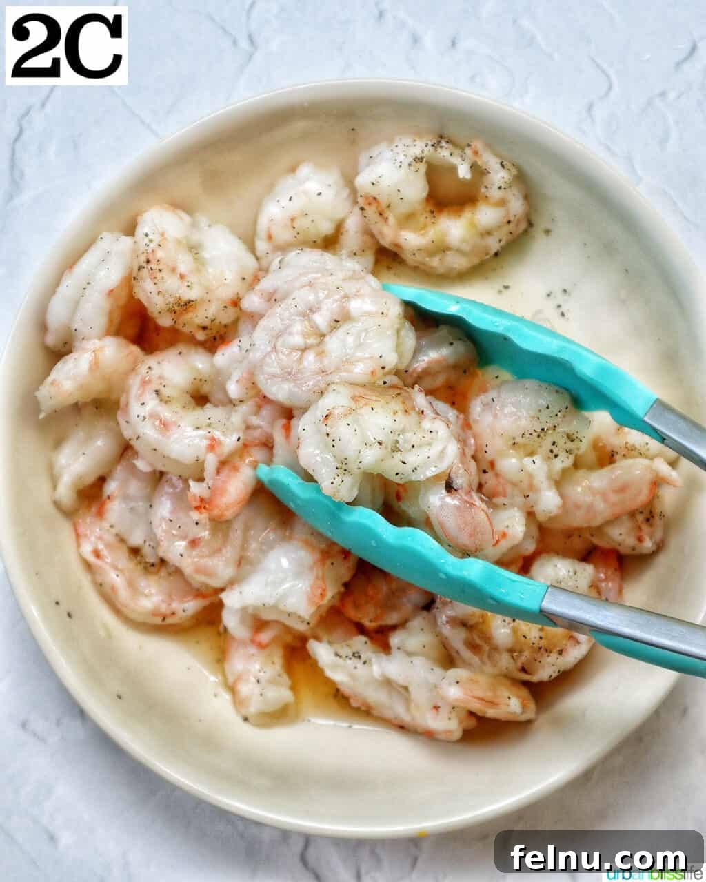 Homemade Prawn Chow Mein Delight 9 Tongs gently tossing the seasoned prawns in a bowl, ensuring even coating.